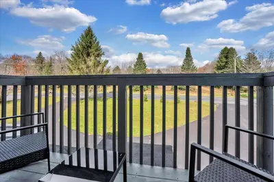 a balcony with two benches and a view of a field at Heart of Pocono Mtn 3bd 2ba Gameroom Pocono Raceway in Long Pond