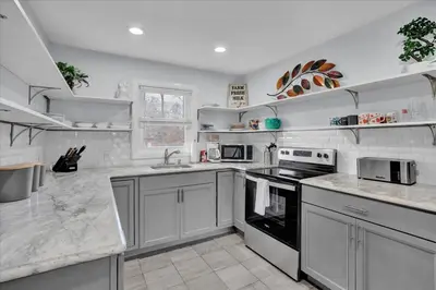 a large kitchen with white cabinets and appliances at Heart of Pocono Mtn 3bd 2ba Gameroom Pocono Raceway in Long Pond