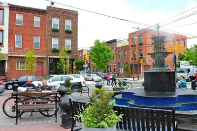 two people sitting at a bench next to a fountain at Double Decker Roofdeck Gorgeous View in Passyunk in Philadelphia