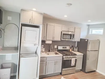 a kitchen with white cabinets and a refrigerator at Unique Studio in York in York