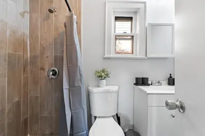 a white bathroom with a toilet and a shower at Whimsical three in Bayonne