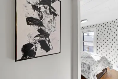 a bedroom with a black and white picture on the wall at Whimsical three in Bayonne