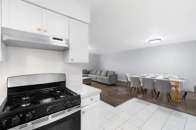 a kitchen with a stove and a table with chairs at UrbanNest XL in Bayonne