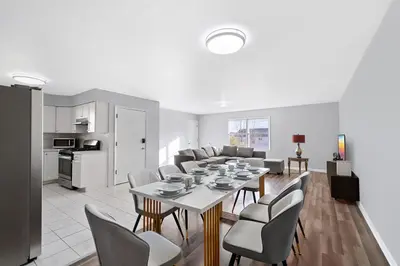 a dining room and living room with a table and chairs at UrbanNest XL in Bayonne