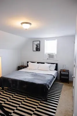 a bedroom with a large bed and a window at Rainforest Retreat 20m to NYC Parking Sleeps 25 in Bayonne