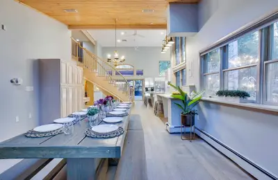 a hallway with a long table in a building with windows at Luxury Villa with Year Round Heated Pool, Sauna, Spa & Fire Pit - Newly Redone in East Stroudsburg