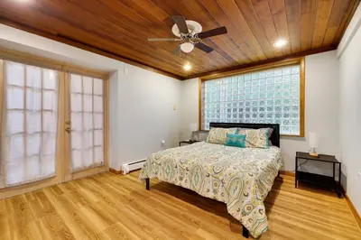 a bedroom with a bed and a ceiling fan at Luxury Villa with Year Round Heated Pool, Sauna, Spa & Fire Pit - Newly Redone in East Stroudsburg