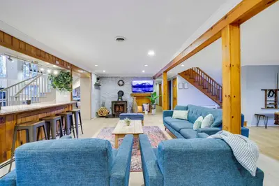 a living room with blue couches and a bar at Luxury Villa with Year Round Heated Pool, Sauna, Spa & Fire Pit - Newly Redone in East Stroudsburg