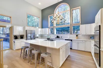 a large kitchen with white cabinets and a large island at Luxury Villa with Year Round Heated Pool, Sauna, Spa & Fire Pit - Newly Redone in East Stroudsburg