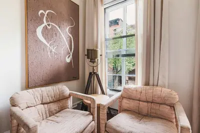 a living room with two chairs and a window at The West Village Gem in New York