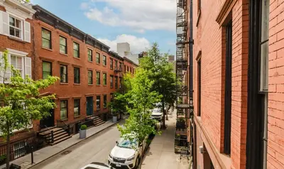 a city street with buildings and cars parked on the street at The West Village Gem in New York