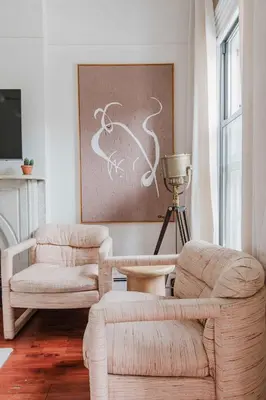 a living room with two chairs and a painting at The West Village Gem in New York