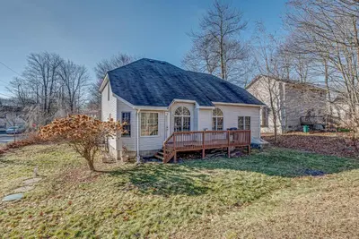 a small white house with a bench in a yard at 11 Mi to Camelback Resort Tobyhanna Home! in Tobyhanna