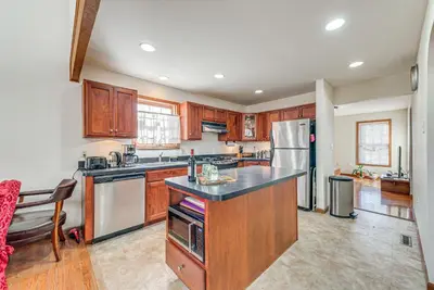a kitchen with wooden cabinets and stainless steel appliances at 11 Mi to Camelback Resort Tobyhanna Home! in Tobyhanna