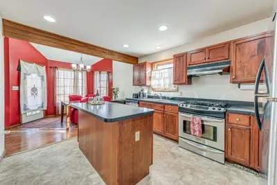 a kitchen with wooden cabinets and a black counter top at 11 Mi to Camelback Resort Tobyhanna Home! in Tobyhanna