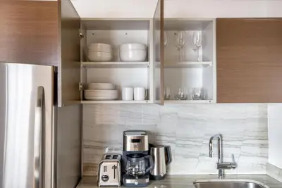 a kitchen with a coffee maker and cups and plates at Midtown 1br w gym elevator nr Rockefeller Ctr NYC-1401 in New York