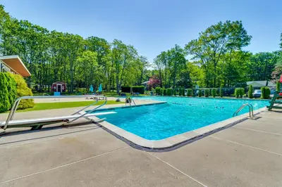 a swimming pool with blue water and trees at Peaceful Pocono Gem! Cabin 6 Mi to Dtwn Jim Thorpe in Jim Thorpe