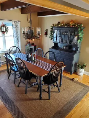a dining room with a wooden table and chairs at Paper Mill Pines Bed and Breakfast in Shickshinny