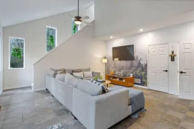 a living room with a couch and a tv at Creekside Recess Hottub Sauna Firepit Gameroom