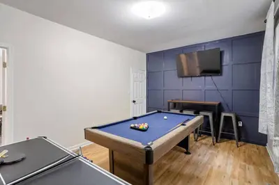 a room with a pool table and a tv at Creekside Recess Hottub Sauna Firepit Gameroom