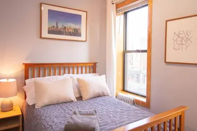 a bedroom with a bed with white pillows and a window at 2 Bedroom Apt with 3 Beds - Friends & Family in New York