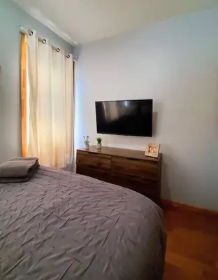 a bedroom with a bed and a flat screen tv at 2 Bedroom Apt with 3 Beds - Friends & Family in New York