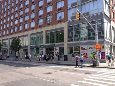 a group of people crossing a street in front of a building at 2 Bedroom Apt with 3 Beds - Friends & Family in New York