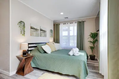 a bedroom with a green bed and a window at POCONOS BRAND NEW LAKEFRONT Oasis 1 ACRE, HOTTUB GAMEROOM FIREPITS TALK ABOUT PRIVACY in Albrightsville