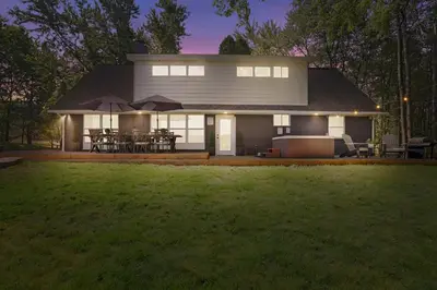 a white house with a lawn in front of it at POCONOS BRAND NEW LAKEFRONT Oasis 1 ACRE, HOTTUB GAMEROOM FIREPITS TALK ABOUT PRIVACY in Albrightsville