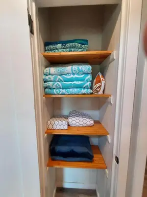 a closet with wooden shelves and blue towels at POCONOS BRAND NEW LAKEFRONT Oasis 1 ACRE, HOTTUB GAMEROOM FIREPITS TALK ABOUT PRIVACY in Albrightsville
