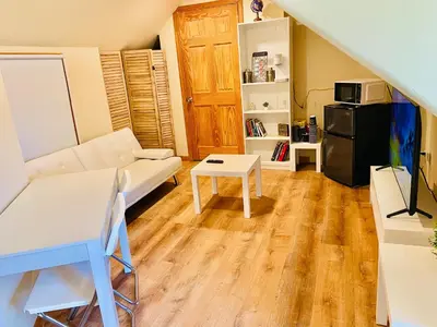 a living room with a couch and a table at Bright, Stylish & Cozy Private Attic Unit near NYC! in Haledon