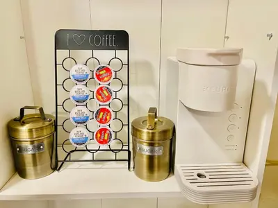 a shelf with a coffee dispenser and two cups at Bright, Stylish & Cozy Private Attic Unit near NYC! in Haledon