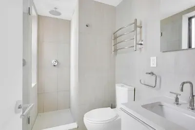 a white bathroom with a toilet and a sink at Little Italy 1br w wd nr SoHo NYC-756 in New York