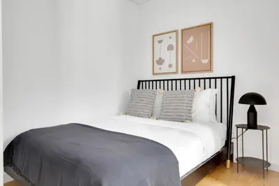 a bedroom with a white bed and a clock on the wall at Little Italy 1br w wd nr SoHo NYC-756 in New York