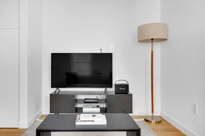 a living room with a tv and a coffee table at Little Italy 1br w wd nr SoHo NYC-756 in New York