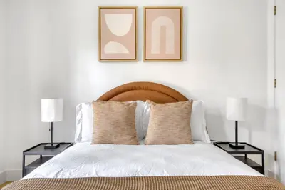 a bedroom with a bed with two lamps and two pictures on the wall at BK Heights 2BR w WD Elevator nr Promenade NYC-910 in Brooklyn