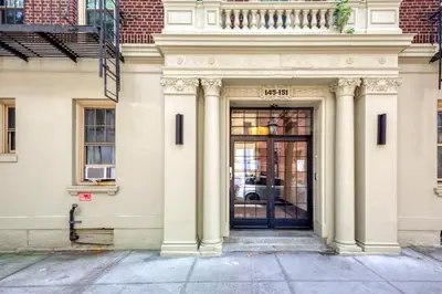 a white building with a door with a balcony at BK Heights 2BR w WD Elevator nr Promenade NYC-910 in Brooklyn