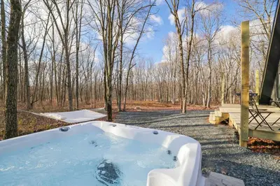 a hot tub in the middle of the woods at Modern A-frame in woods with Sauna, HotTub, Privacy in Albrightsville