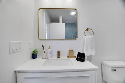 a bathroom with a white sink and a mirror at Modern A-frame in woods with Sauna, HotTub, Privacy in Albrightsville