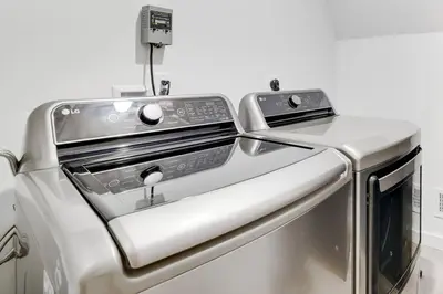 a stainless steel washer and dryer in a kitchen at Modern A-frame in woods with Sauna, HotTub, Privacy in Albrightsville