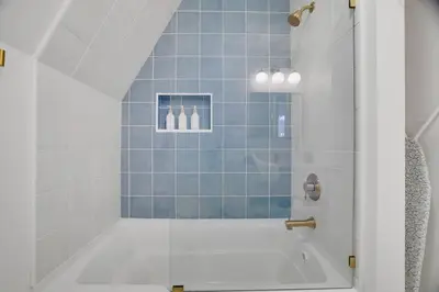 a bathroom with a tub with blue tiles at Modern A-frame in woods with Sauna, HotTub, Privacy in Albrightsville