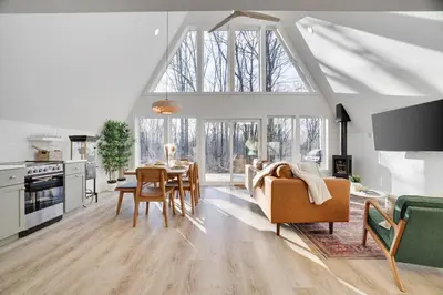 a living room with a couch and a table at Modern A-frame in woods with Sauna, HotTub, Privacy in Albrightsville