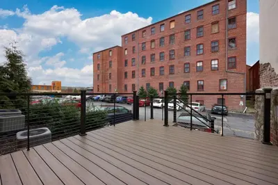 a wooden deck in front of a brick building at Sweet Lancaster Apt. B in Lancaster