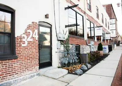 a brick building with a door on a street at Sweet Lancaster Apt. B in Lancaster