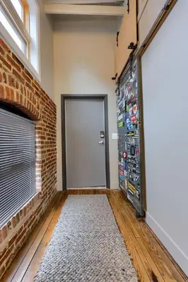 a room with a door and a brick wall at Sweet Lancaster Suite in Lancaster