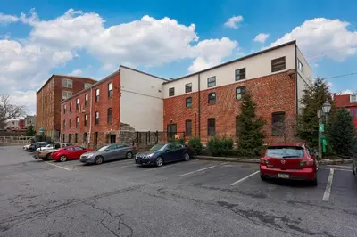 a parking lot with cars parked in front of a building at Sweet Lancaster Suite in Lancaster