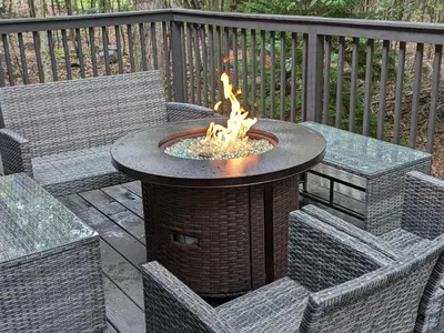 a fire pit on a deck with two chairs at Poconos Chalet in Tobyhanna