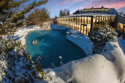 a pool covered in snow with people swimming in it at Skylift Lodge - Luxury Mountain Creek family condo in Vernon Township