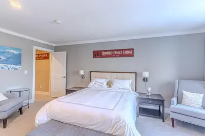 a bedroom with a large bed and a chair at Skylift Lodge - Luxury Mountain Creek family condo in Vernon Township