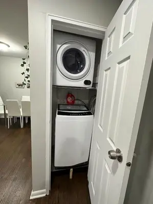 a washer and dryer in a room with a door at Cozy 2 BR suite, 10 min to NYC &Times Sq in West New York